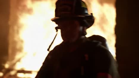 a firefighter fights fierce flames in a burning structure at night. the scene is filled with bright fire and smoke as emergency responders work to control the situation and ensure safety.