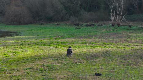 Männlicher-Fotograf,-Der-Naturfotos-Am-Seeufer-Macht,-Während-Er-Auf-Dem-Feld-Sitzt