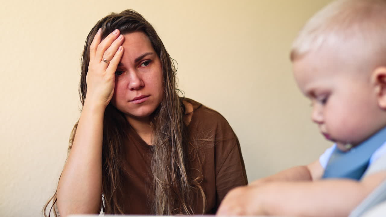 Mãe com o telefone nas mãos, elevando a voz para o filho pequeno. Mulher exausta pela maternidade, elevando a voz para o filho. Depressão pós-parto em mulher