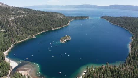 descending close-up aerial shot of emerald bay with boat traffic in lake tahoe