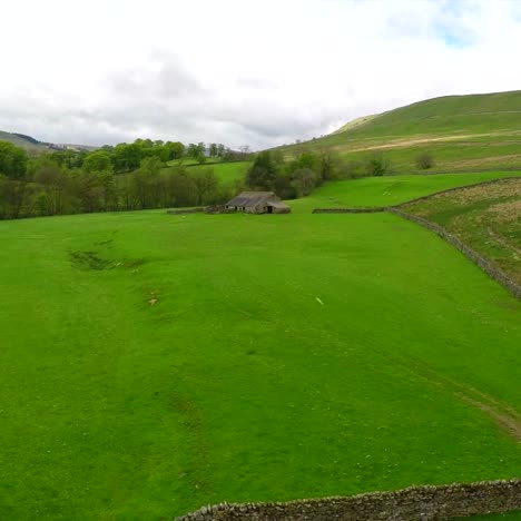 Aerial-shot-over-farm-fields-and-stone-walls-in-England-Wales-Scotland-or-Ireland