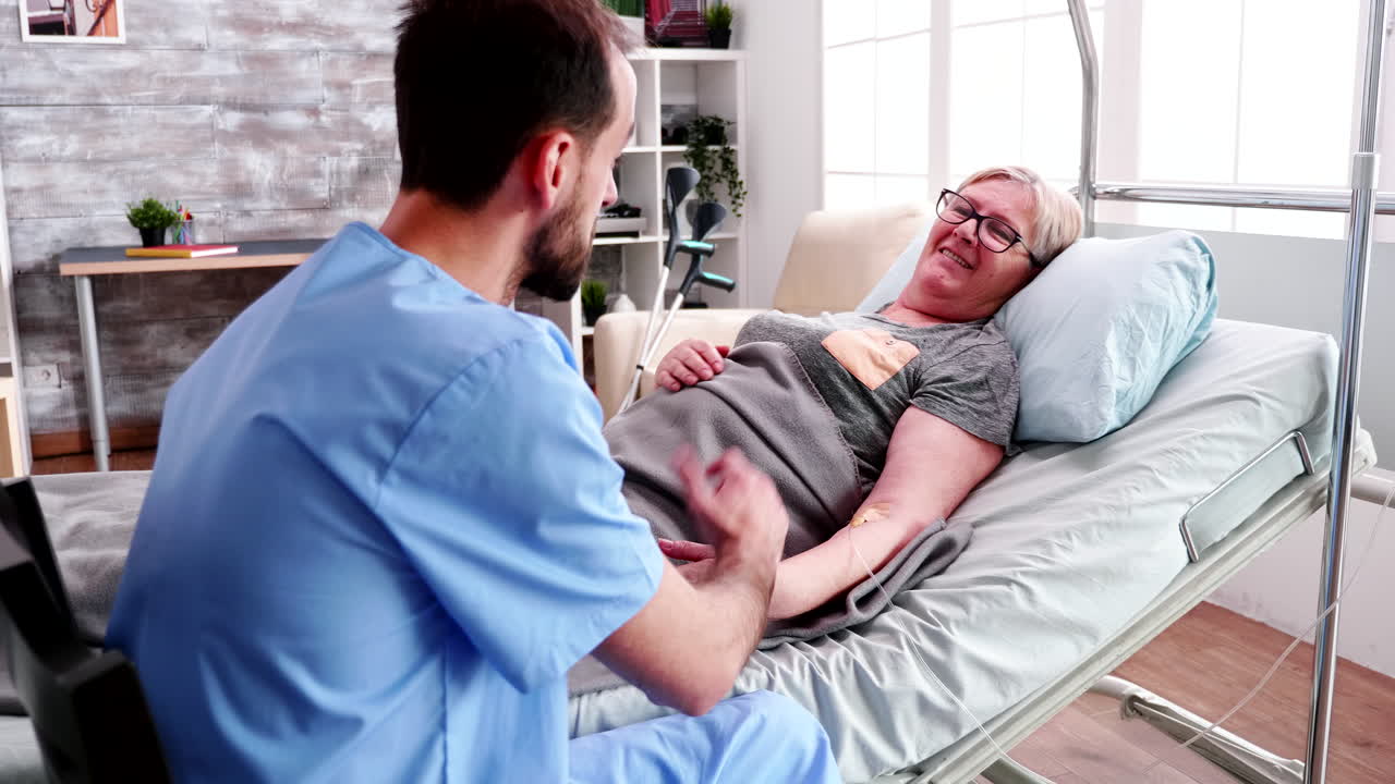 Retired old woman in nursing home talking with caucasian male nurse
