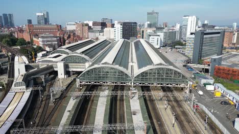 aerial drone flight over piccadilly train station with a skyline view of manchester city centre