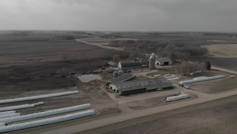 Aerial-drone-shot-moving-towards-a-farm-in-the-day