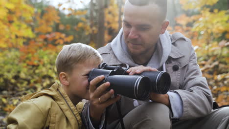 vater und sohn sitzen im wald