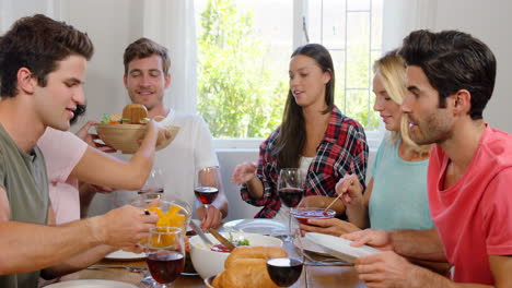 amigos felices comiendo un almuerzo saludable con vino