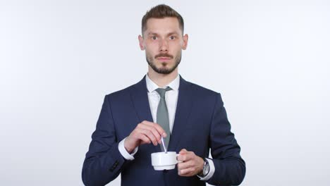 cinemagraph de un hombre de negocios sin emociones mezclando café