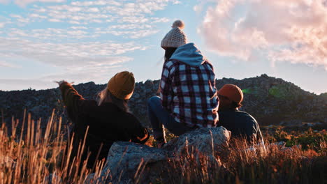 group of friends drinking together in beautiful countryside hanging out having conversation enjoying sunset on relaxed summer vacation