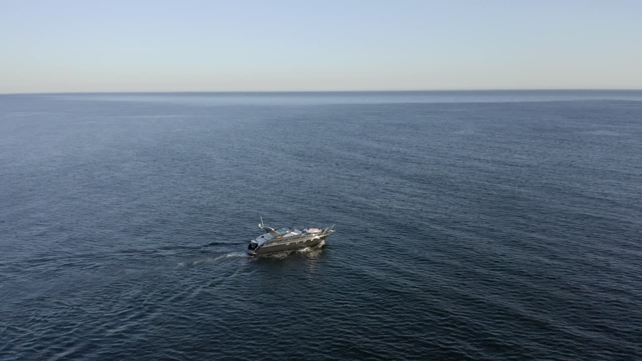 Yacht Cruising On The Wide Blue Ocean In Slow Motion Before Sunset In Albufeira, Portugal - aerial drone, orbiting shot