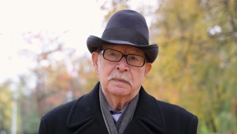 portrait of an elderly man in a hat outdoors