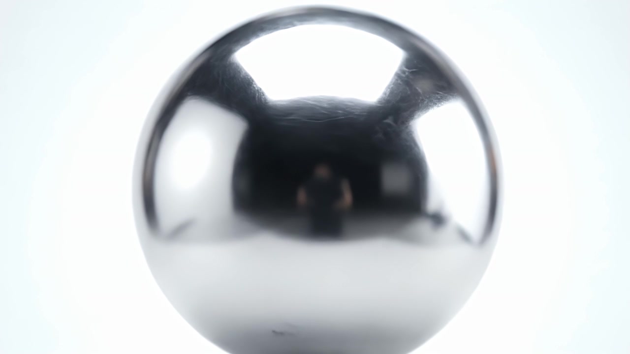 Sfera cromata lucida che riflette un ambiente da studio