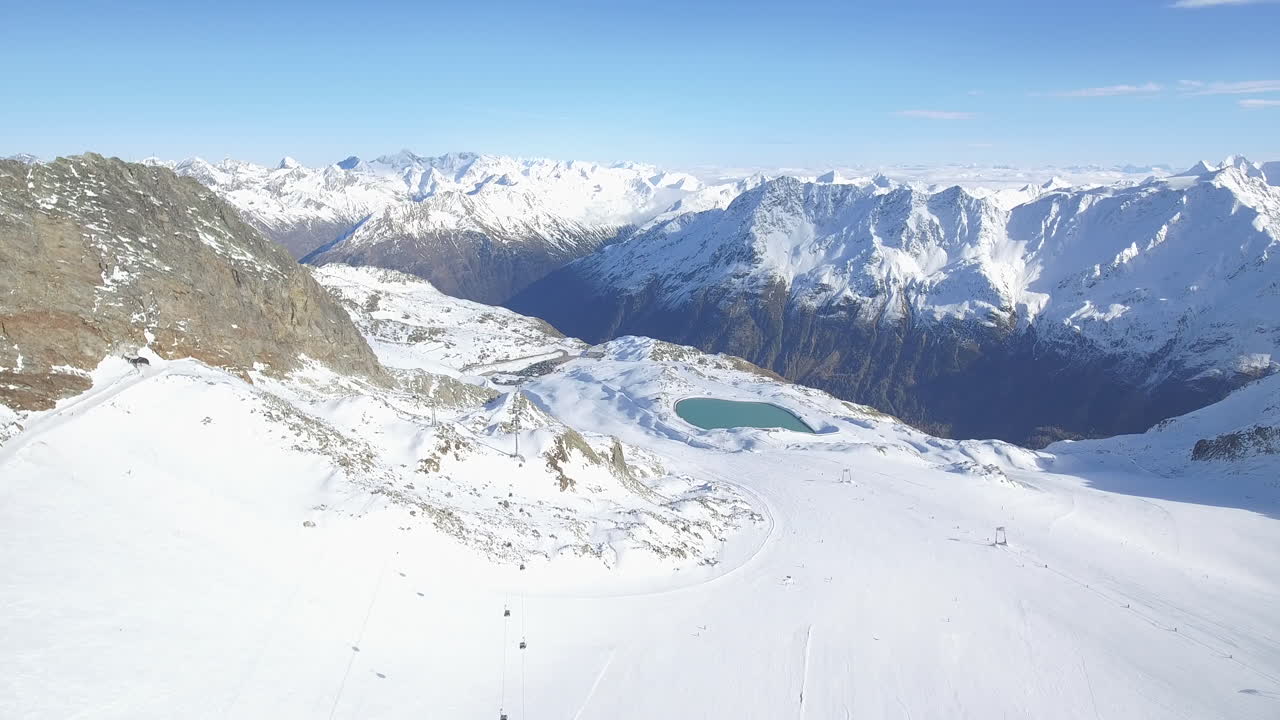 Tilting up Drone Shot Revealing Ski Slope with Mountains and Lake in the Background