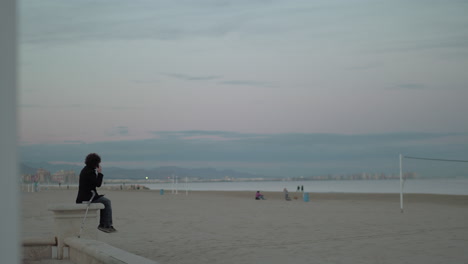 man talking on his cellphone beside the sea