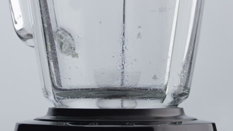 piece broccoli blending blender close up. vegetable cutting with mixer blades.