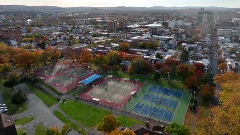 ascendente aérea con luz dorada del parque de la ciudad con canchas de baloncesto