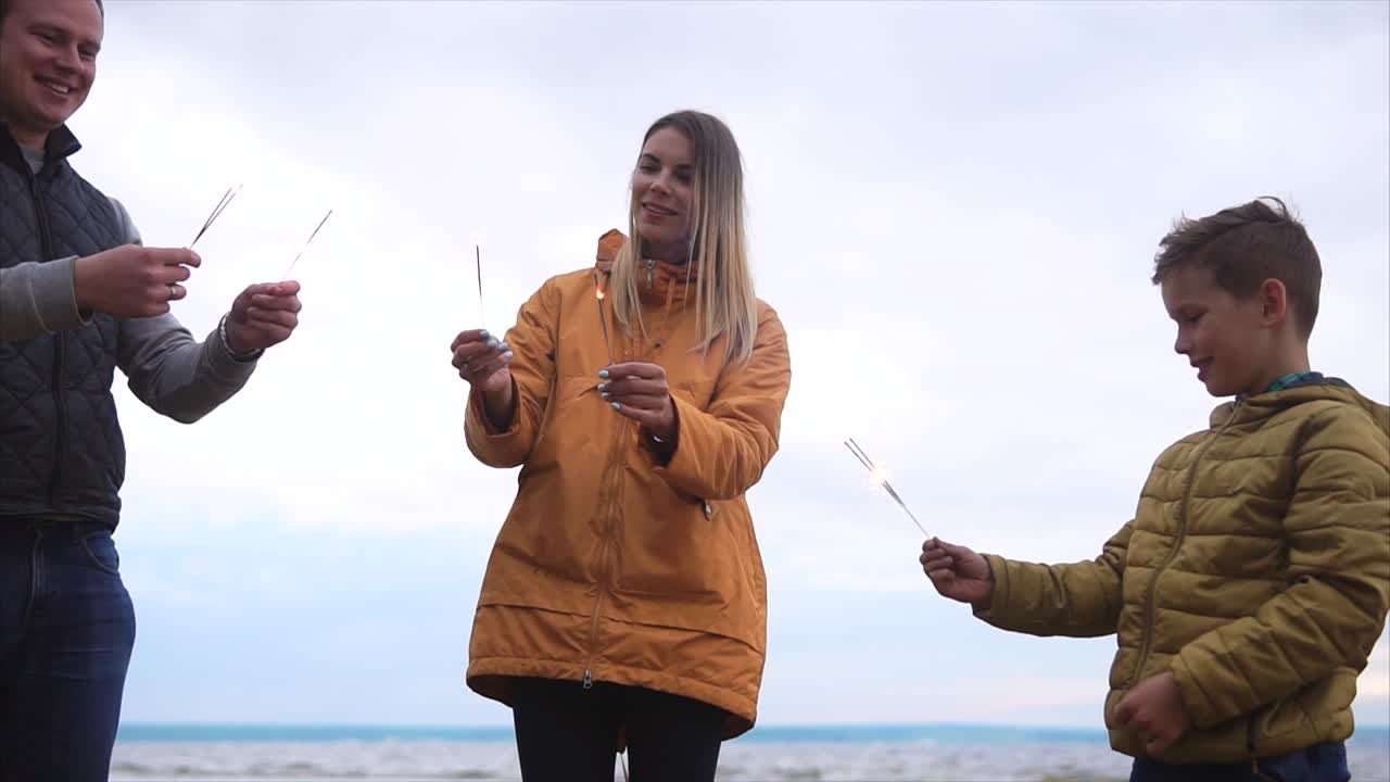 Family Celebrating on the Beach with Sparkler