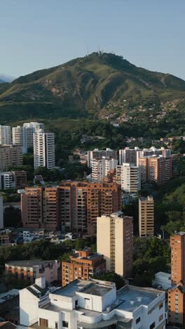 aerial view of western cali, normandia neighborhood, colombia. pull back shot with three crosses hill in the background vertical