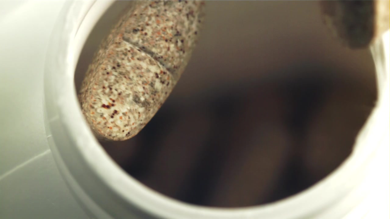 Slow Motion Drop of a Pill into a White Container
