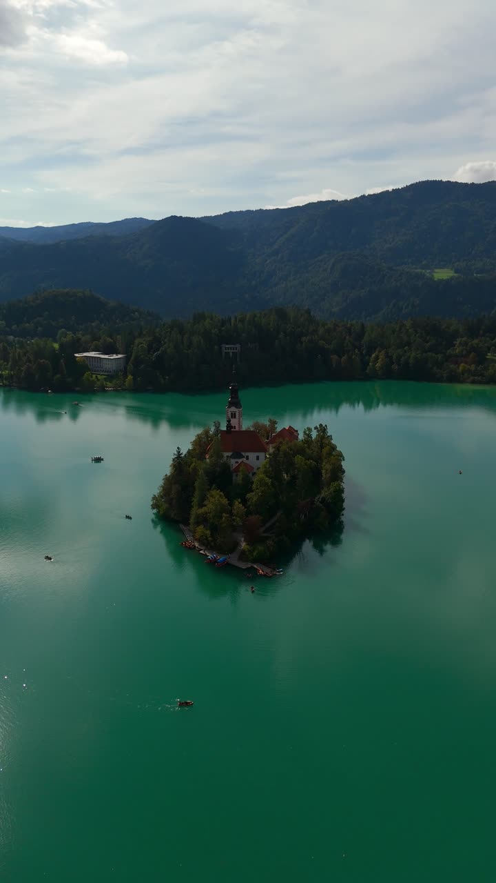 Ripresa aerea verticale di inquadratura d'ambiente della splendida Chiesa dell'Assunzione di Santa Maria, Slovenia, giornata soleggiata e suggestiva