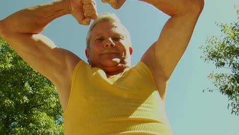 an older man flexes his muscles