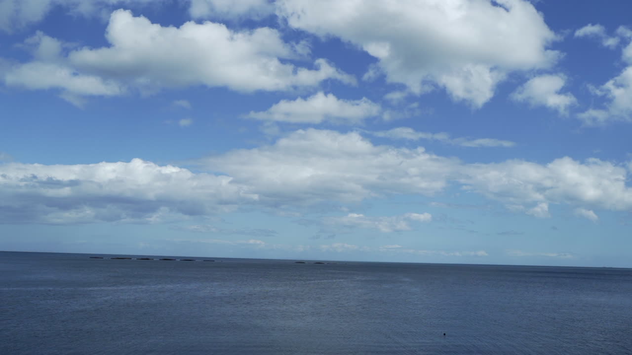 움직이는 차에서 구름과 바다가 있는 푸른 하늘