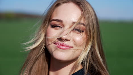 pretty model on field. facial portrait of beautiful blonde walking and smiling on camera. happy young woman with blue eyes posing outdoors.