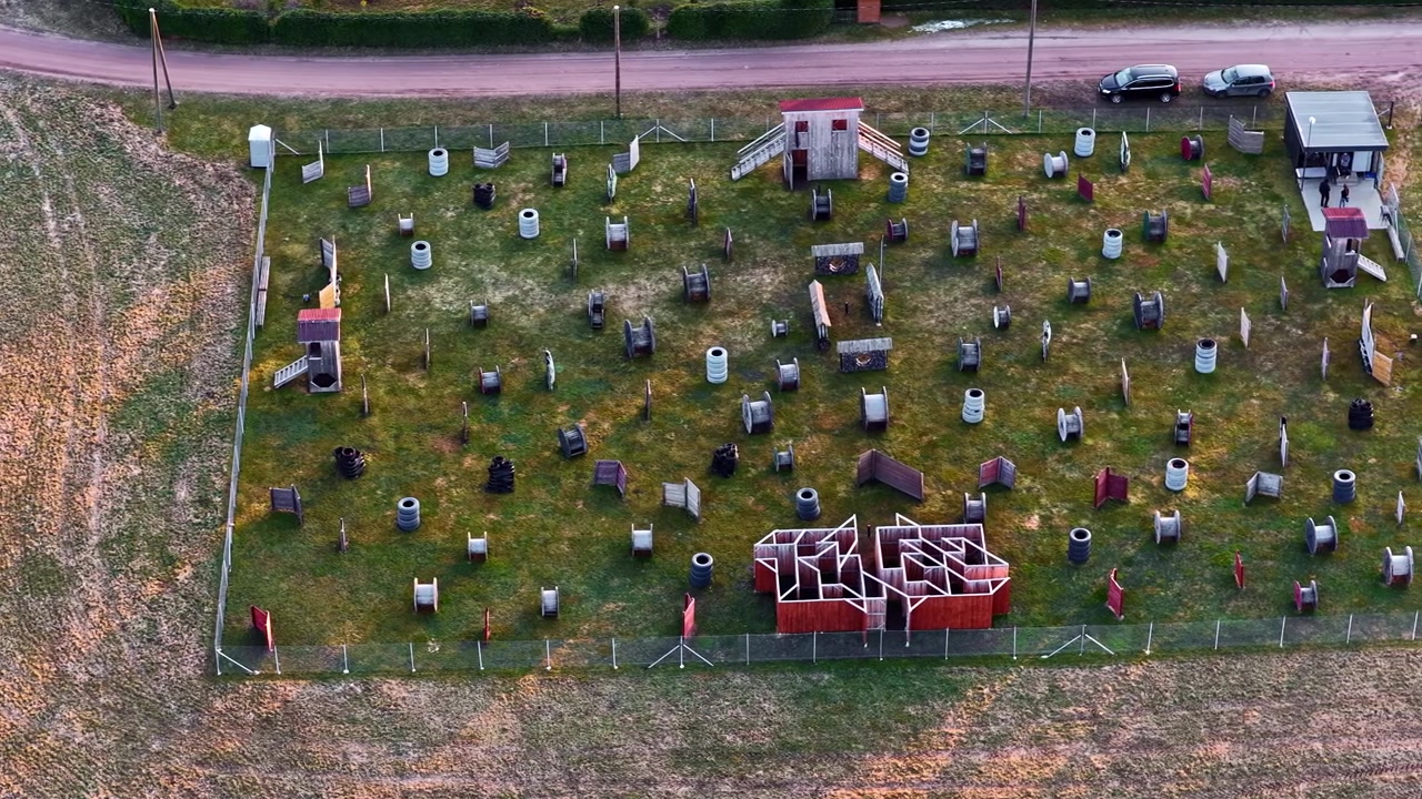 Arena vuota all'aperto per paintball o airsoft al tramonto, vista aerea.