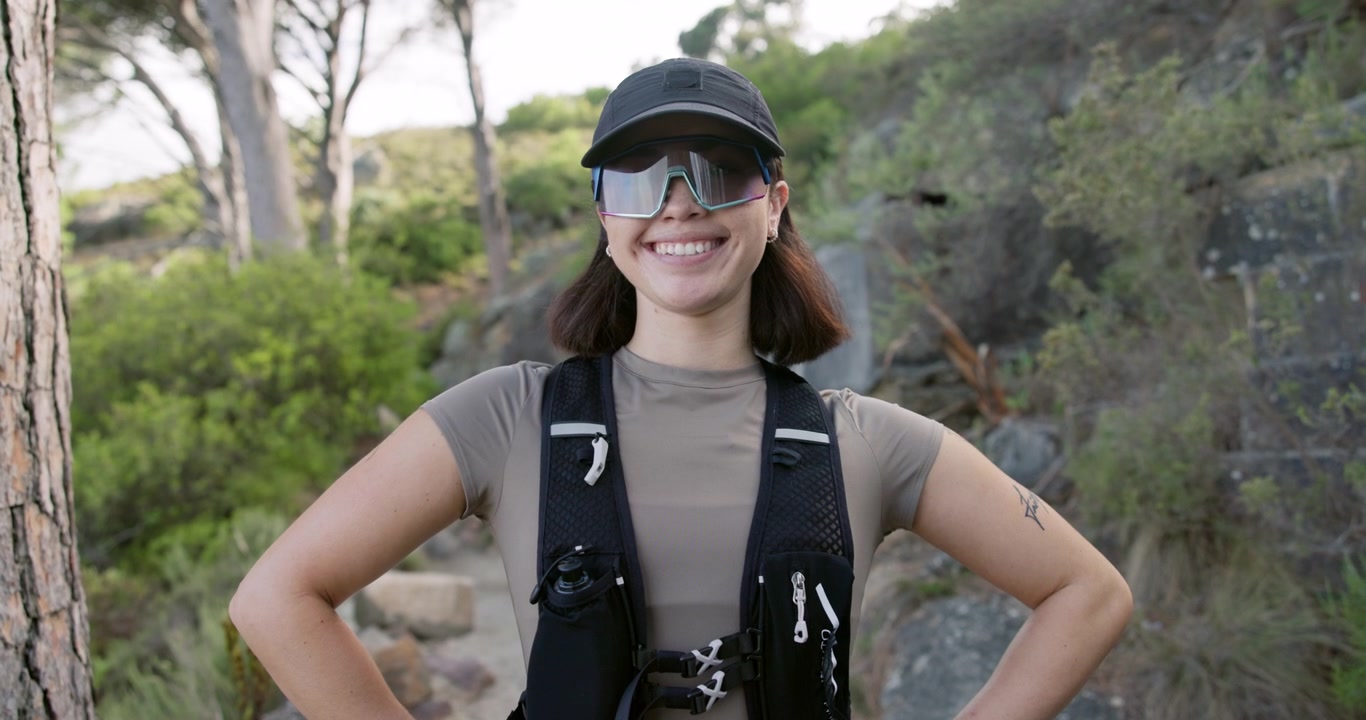 Smiling Female Trail Runner Standing on Mountain Path