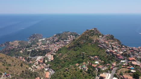 medieval italian town scattered over green mountains near mediterranean sea