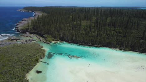 the amazing crystal clear waters of the natural pool at oro bay in the isle of pines - aerial parallax reveal