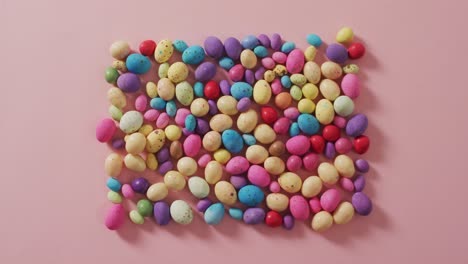 video of decorated colorful easter eggs on a pink surface