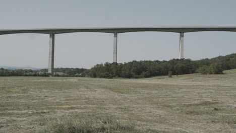 panning view from a highway bridge and its huge columns.