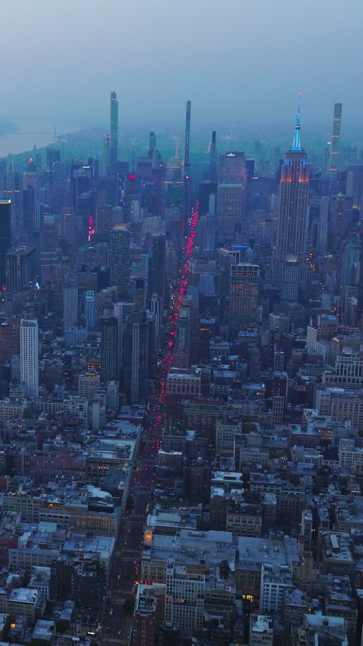 Fascinating panorama of splendid New York in the coming evening. Blue fog covering the metropolis at dusk. Aerial view. Vertical video