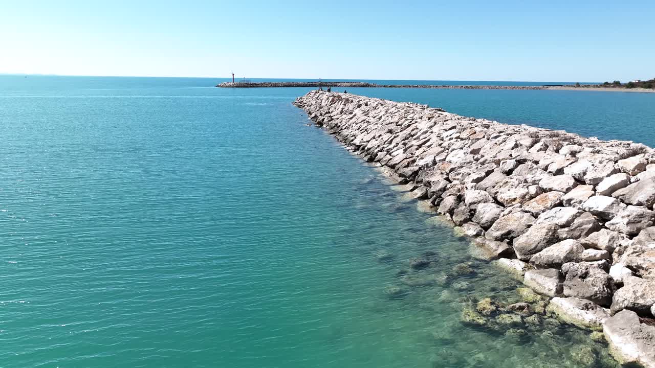 embarcadero de rockwall en la entrada del puerto con agua azul cristalina, plataforma rodante aérea