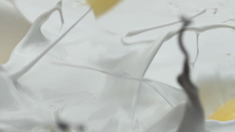 pineapple falling fresh milk making splashes in super slow motion close up.