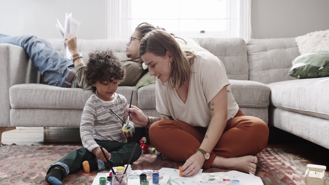 un niño pequeño pintando con su madre en casa