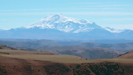 majestic mountain range with snow-capped peak and rolling hills