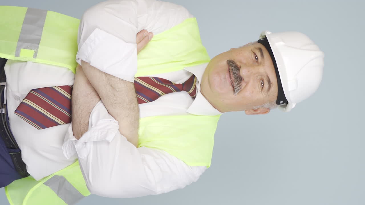 vídeo vertical del ingeniero cruza los brazos y se ríe de la cámara.