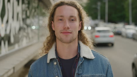 portrait of confident young man smiling looking at camera enjoying independent student lifestyle in urban city street