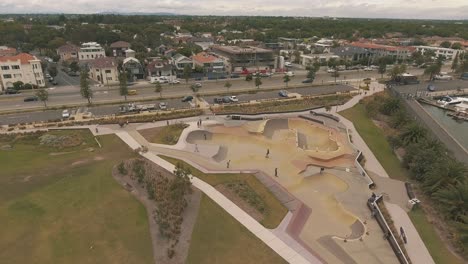 Drohnenantenne-über-Dem-Skatepark-St.-Kilda-Mit-Skateboardfahrern,-Die-In-Die-Schüssel-Fahren-Und-Fallen