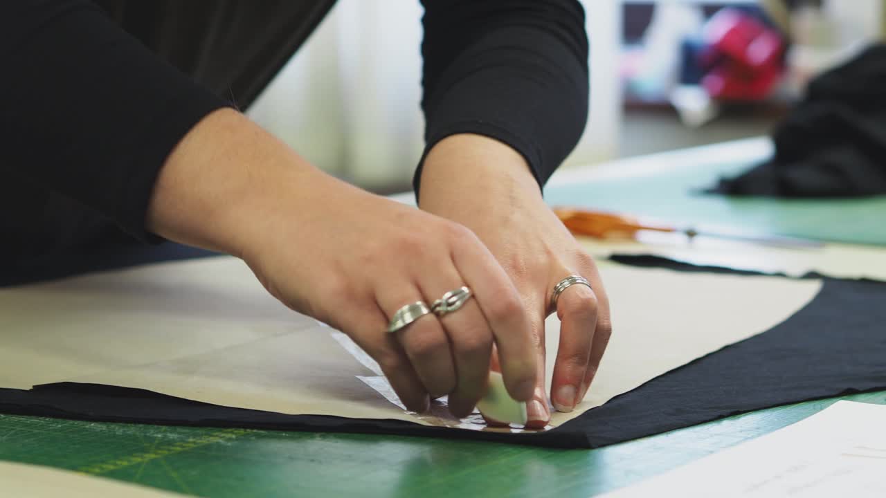 una mujer marcando tela con chack al lado de la plantilla