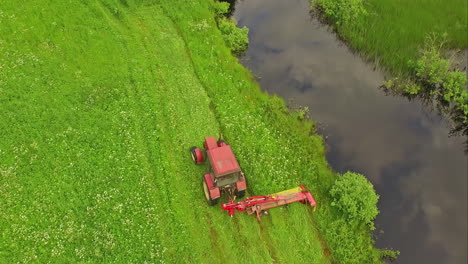 Traktor-Mit-Seitenmäher-Schneidet-Gras-Entlang-Des-Kanalufers-Auf-Der-Grünen-Wiese