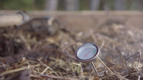 slow motion - steam rises around the compost thermometer