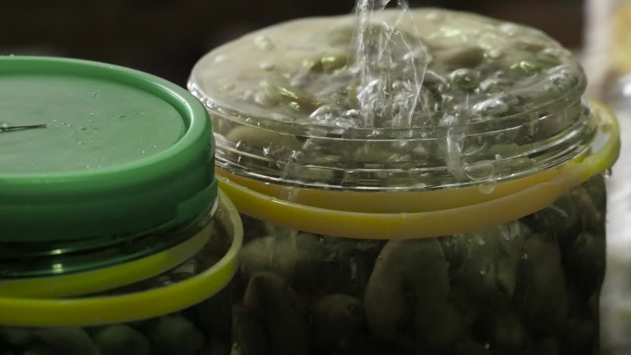 llenando las jarras de aceitunas de mesa con agua