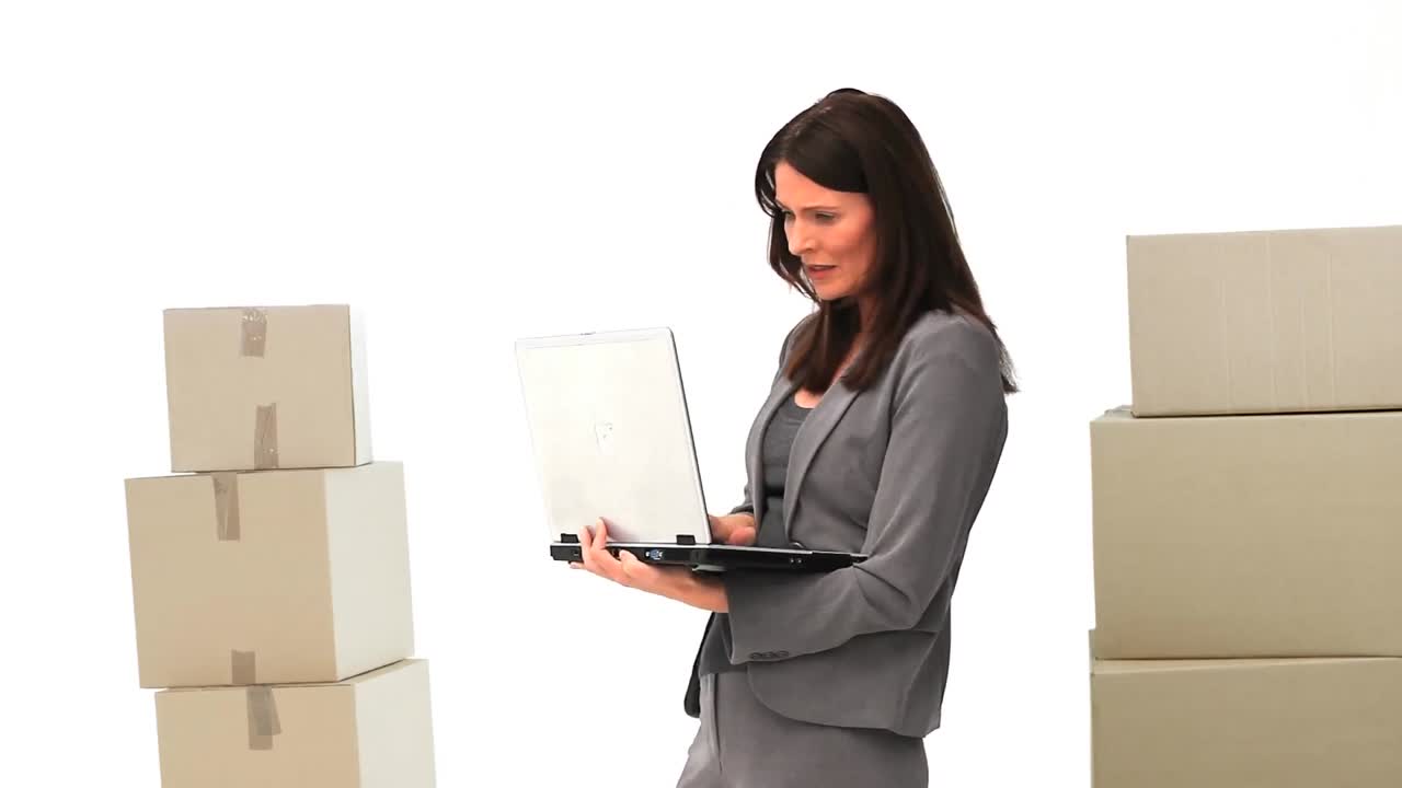 animación de una mujer usando una computadora portátil con pilas de cajas sobre un fondo blanco