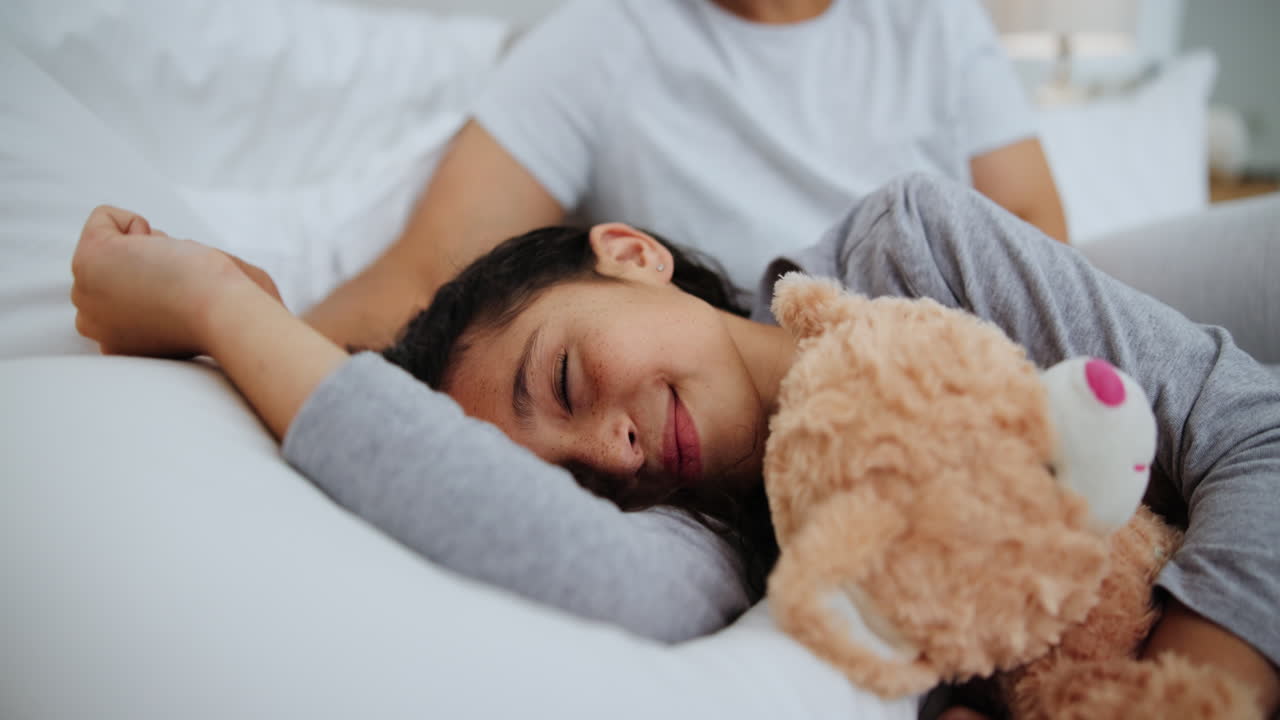 잠자는 딸을 키스하는 어머니