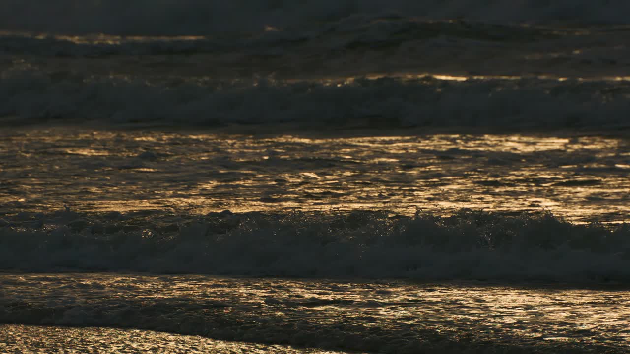 아름다운 바다의 파도와 모래, 황금빛 해가 지는 동안 열대 해변의 근접 텍스처, 고품질의 4k 느린 동작 여행 휴가 개념