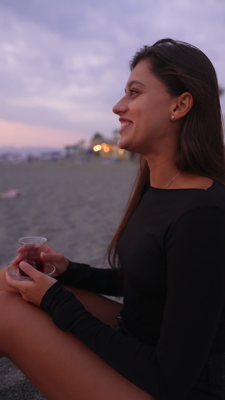 mujer disfrutando de un té turco en la playa al atardecer