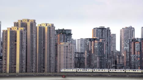 Aboveground-Chongqing-Metro-passes-in-front-of-apartment-buildings-with-sunset-glow