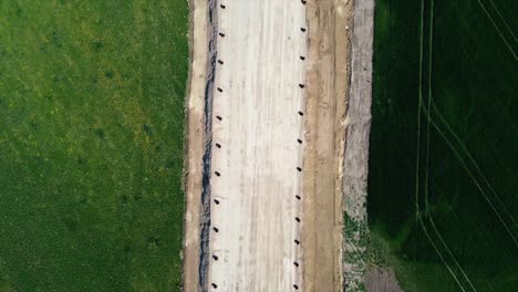 AERIAL---Railroad-construction-and-farmland,-Baden,-Austria,-top-down-wide-shot